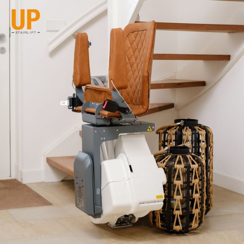 Treppenlift mit braunen Sitzen, montiert an einer Treppe, daneben zwei Koffer in Ibbenbüren Treppenlift mit braunen Sitzen, montiert an einer Treppe, daneben zwei Koffer in Ibbenbüren