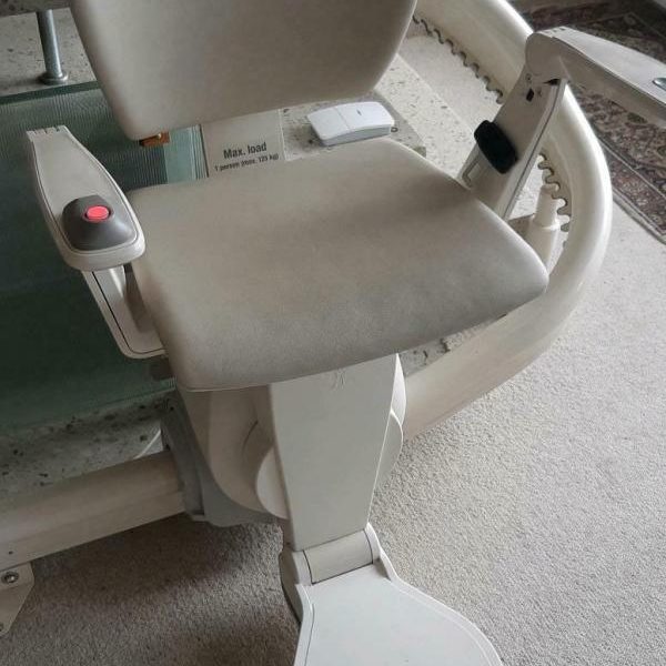 Ein grauer Badestuhl mit Armlehnen und Sitzfläche auf einem Rollstuhl. Ein grauer Badestuhl mit Armlehnen und Sitzfläche auf einem Rollstuhl.